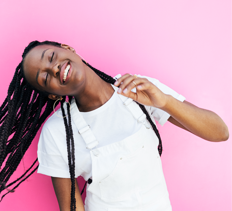 Smiling Girl With Braided Hair In Front Of Pink Background